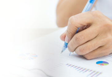 hand-holding-pen-over-documents